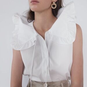 Zara woman’s white sleeveless ruffle collar button up top. Size XS.